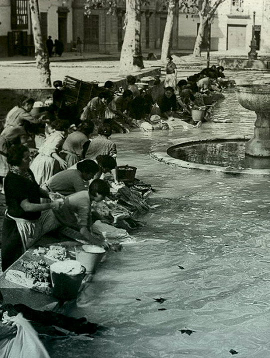 fotografia antiga del safareig - llavador, de la Plaça de la Bassa de Xàtiva, secció amb persones llavant la roba a mà